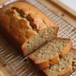 Freshly baked banana zucchini bread cooling on a rack.