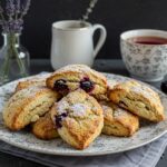 Delicious blackberry lavender white-chocolate scones served on a plate, showcasing the delightful combination of flavors in a perfect breakfast setting.