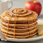final presentation of cinnamon roll pancakes, showcasing the swirls of cinnamon and icing, perfect for a tempting breakfast.
