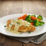 Final presentation of creamy garlic chicken, showcasing the rich sauce and fresh herbs in an appetizing dish.