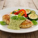 Final presentation of Creamy Pesto Chicken Delight with vibrant colors and fresh basil, perfect for a savory dining experience.