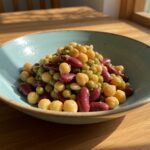 A delicious visual of a dense bean salad, featuring a colorful medley of beans and vegetables in a rustic bowl, perfect for healthy eating.