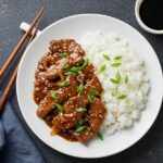 Elegant presentation of Easy Chinese Pepper Steak served with steamed rice and garnished with scallions, perfect for a delightful meal.