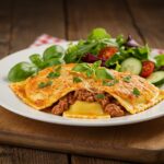 Exquisite display of foil-pack ravioli dinner, highlighting the finished dish with ravioli, vegetables, and garnishes for a mouthwatering presentation.