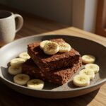 Delicious Healthy Baked Oatmeal Brownies served with banana slices, emphasizing healthful dessert options in a cozy dining setting.