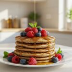 Final presentation of High-Protein Pancakes stacked high with berries and syrup, perfect for a nutritious and delicious breakfast.