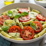 Final presentation of Light and Creamy Pesto Caprese Pasta Salad, featuring vibrant colors and fresh ingredients, perfect for any gathering.