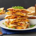 Final presentation of Loaded BBQ Bacon Cheese Quesadilla Bombs, beautifully plated with BBQ dipping sauce, perfect for sharing or enjoying alone.