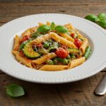 A vibrant bowl of One-Pot Summer Veg Pasta presented with fresh basil and Parmesan cheese, perfect for a summer meal.