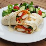 Delicious Savory Chicken Wraps with garlic cream sauce, beautifully plated with a fresh salad on the side.