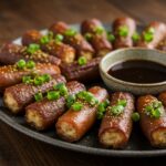 Delicious smoked shotgun shells bacon served on a rustic platter, garnished with green onions, perfect for gatherings and parties.