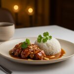 Delicious and visually appealing caramelised soy chicken in garlic ginger broth with rice, ready to be served in an inviting dinner setting.