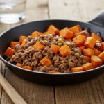 Stunning presentation of ground beef and sweet potatoes skillet, showcasing a well-cooked meal on a rustic dining table.