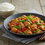 Final presentation of Spicy Ginger Chicken Delight, featuring vibrant chicken and vegetables, served with rice for a delicious meal.