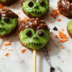 Colorful platter featuring creepy-cute Halloween-themed finger foods with bright orange, green, and purple decorations, including spooky-shaped sandwiches, monster cupcakes, and decorated cookies, all artfully arranged on a festive Halloween-themed tablecloth with seasonal accents and themed props.