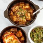 A cozy dinner scene featuring a small round crockpot with a steaming serving of hearty chicken pasta, topped with fresh herbs and melted cheese. The dish is presented on a rustic wooden table with a side of colorful roasted vegetables, and the crockpot's lid is slightly ajar, revealing the creamy, flavorful contents. Natural lighting emphasizes the warm, inviting colors of the meal and the textured surface of the dish.