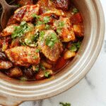 Colorful crockpot fajitas featuring tender sliced bell peppers, onions, and strips of seasoned chicken or beef arranged on a rustic plate with garnishes of cilantro and lime wedges, vibrant red and green peppers contrasting with the savory meat, all plated with a side of warm tortillas and fresh toppings.