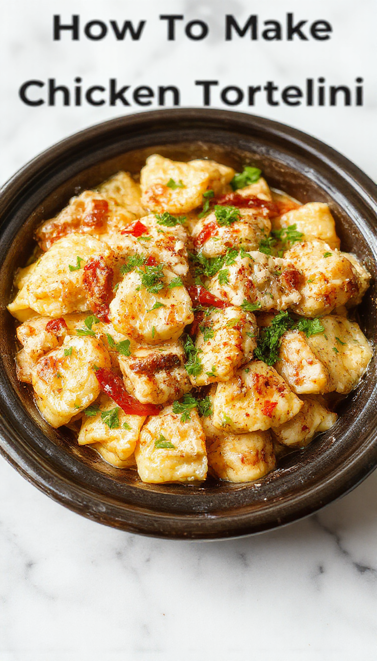A close-up of a vibrant, steaming bowl of chicken tortellini pasta in a rich, savory broth. The tortellini, golden-brown and plump, are surrounded by tender chicken chunks and fresh herbs, all presented in a rustic white bowl set on a wooden surface. Steam gently rises from the dish, highlighting its warmth and hearty appeal.