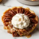 A golden-brown pecan pie with a glossy caramel glaze, topped generously with toasted pecans, artfully sliced to reveal a rich, gooey filling and flaky crust. The pie is presented on a rustic wooden table, with a fork beside it, emphasizing its classic Southern charm.